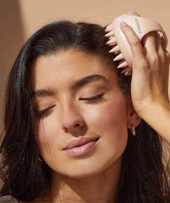 Femme utilisant un masseur cuir chevelu pour femmes rose pour un soin relaxant des cheveux