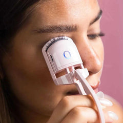 Femme utilisant un recourbe-cils chauffant sans douleur blanc pour des cils relevés et parfaits