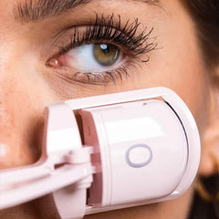 Recourbe-cils chauffant sans douleur utilisé sur un œil avec de longs cils noirs